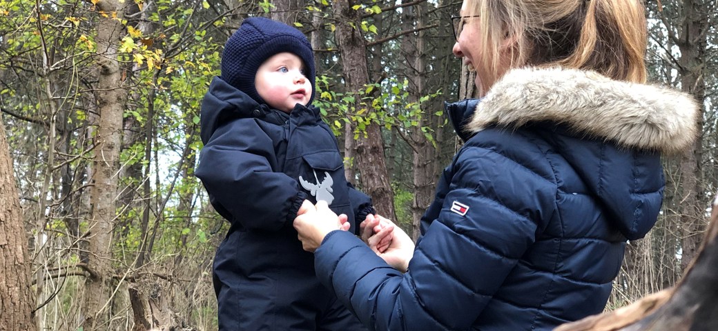 Voksen der leger med barn i skov